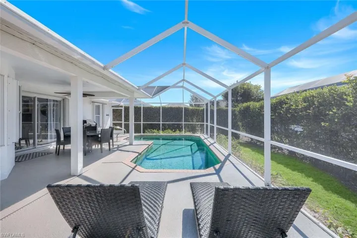 View of pool with a patio, ceiling fan, and glass enclosure