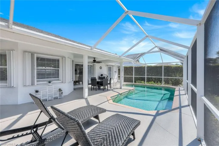 View of pool with a lanai, a patio, and ceiling fan