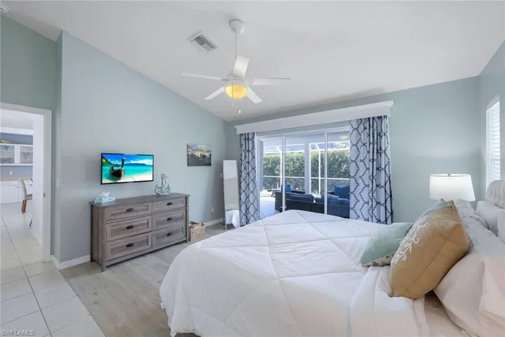 Bedroom with lofted ceiling, light wood-type flooring, and ceiling fan