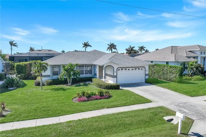 Ranch-style home featuring a garage and a front lawn