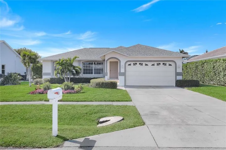 Ranch-style home featuring a garage and a front yard
