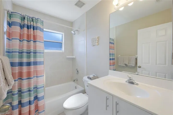 Full bathroom featuring vanity, toilet, and shower / bath combo with shower curtain