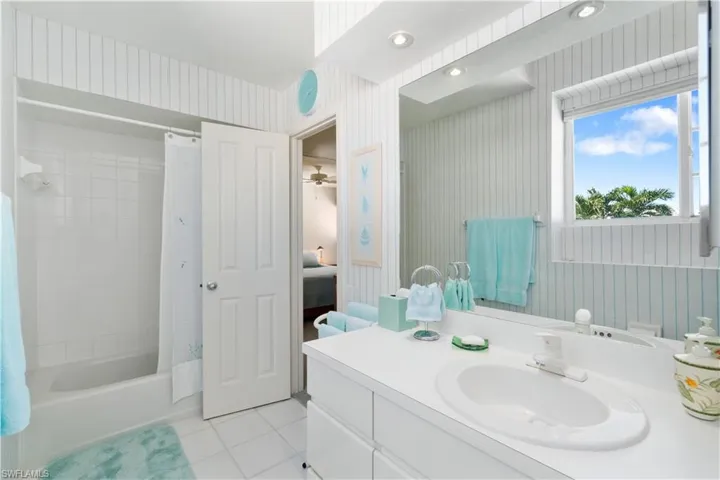 Bathroom featuring tile patterned floors, vanity, and shower / bath combo with shower curtain