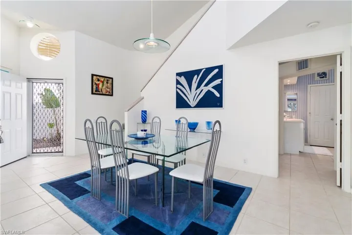 Dining area with light tile patterned floors and a high ceiling