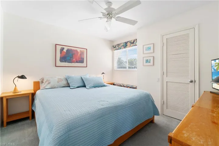 Carpeted bedroom featuring ceiling fan and a closet