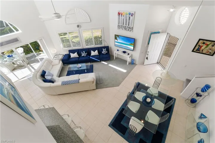 Tiled living room featuring ceiling fan and a high ceiling