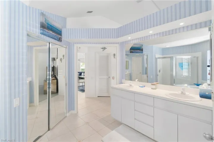 Bathroom featuring tile patterned flooring, vanity, and an enclosed shower