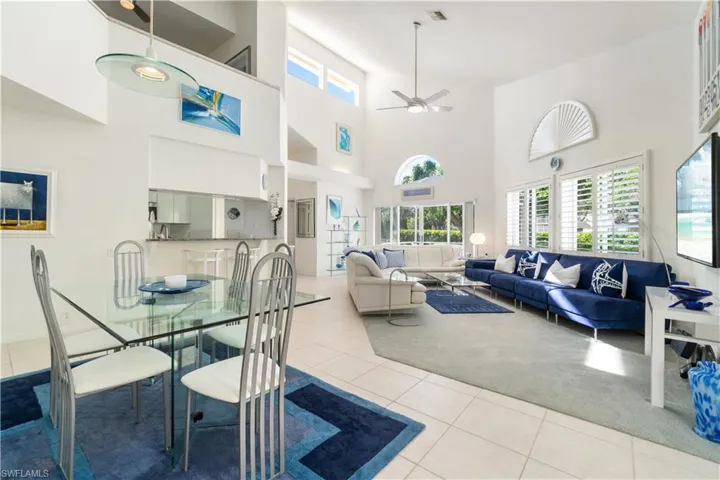 Dining area with ceiling fan, light tile patterned floors, and a high ceiling