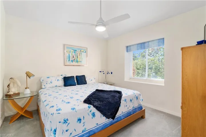 Bedroom with ceiling fan and light carpet
