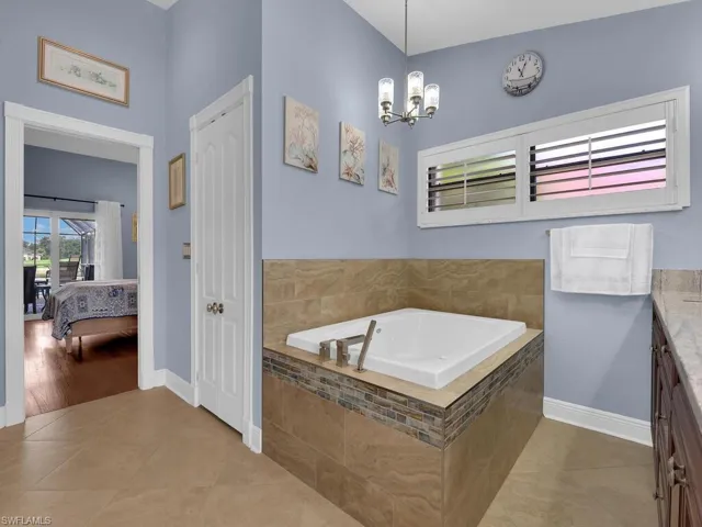 Ensuite bathroom with plenty of natural light, a garden tub, and tile patterned flooring