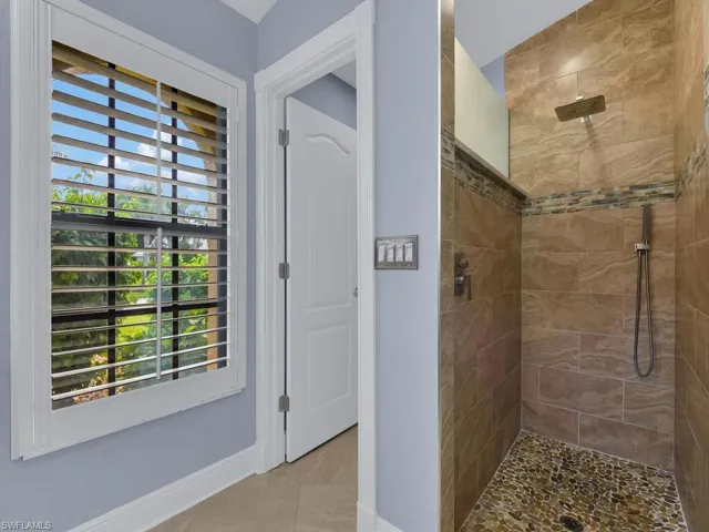 Bathroom with tiled shower and tile patterned flooring
