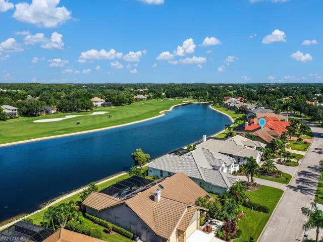 Aerial perspective of suburban area with a nearby body of water and a golf course