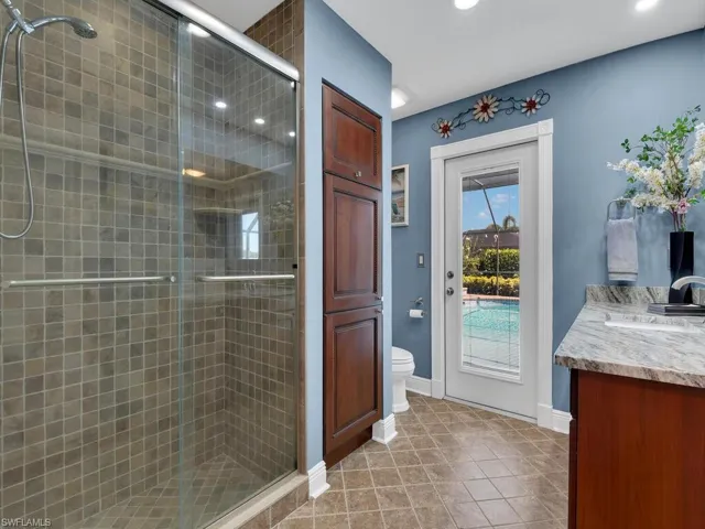 Bathroom featuring tile patterned flooring, a shower stall, vanity, and recessed lighting