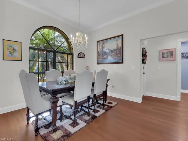 Dining space featuring wood finished floors, a chandelier, and ornamental molding
