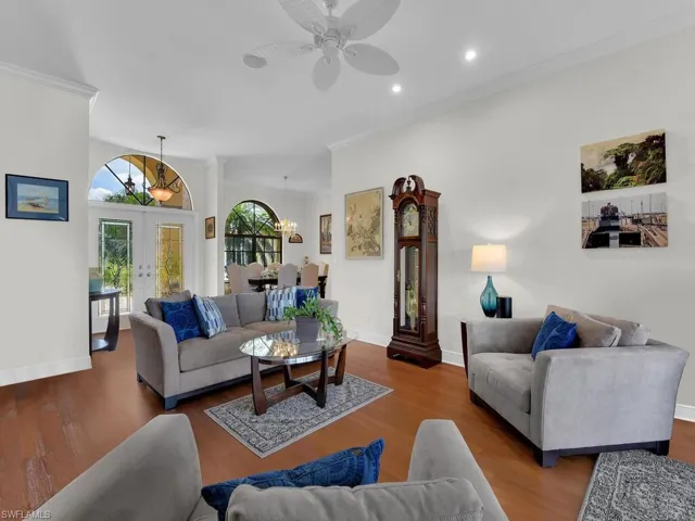 Living room featuring crown molding, wood finished floors, ceiling fan, a chandelier, and recessed lighting