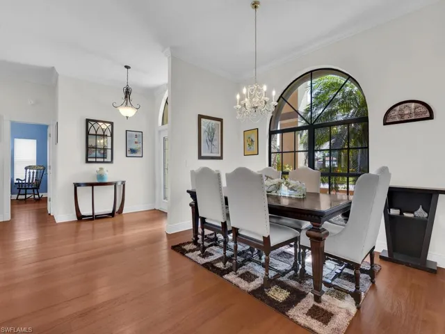 Dining space with crown molding, wood finished floors, and a chandelier