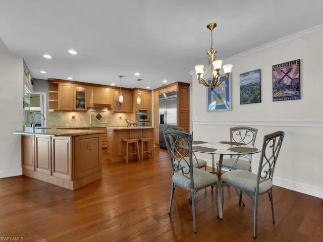Dining area with dark wood finished floors, a chandelier, and recessed lighting