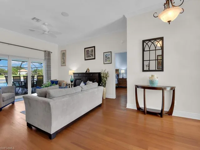 Living area featuring crown molding, wood finished floors, and ceiling fan