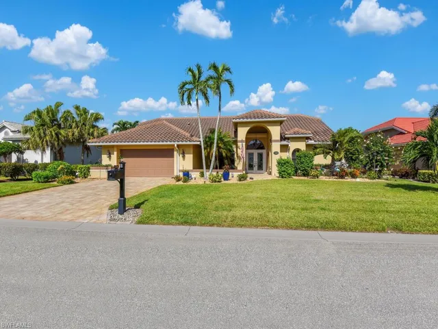 Mediterranean / spanish-style house featuring a front yard, french doors, stucco siding, a tile roof, and an attached garage