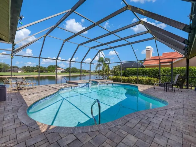 Swimming pool with a water view, a jacuzzi, a patio, and a lanai