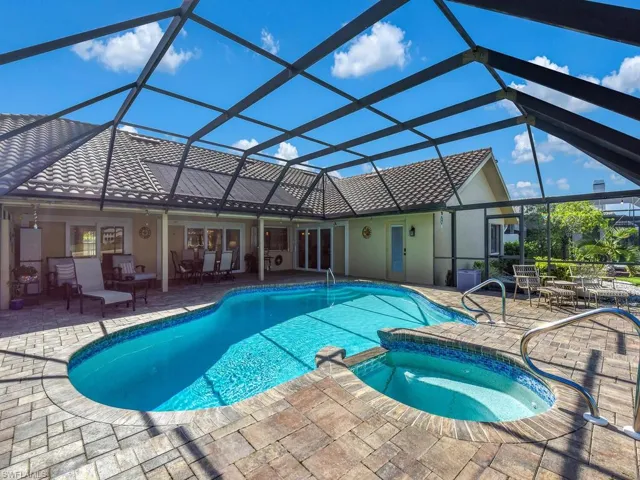 View of swimming pool with a patio area, a pool with connected hot tub, and a lanai