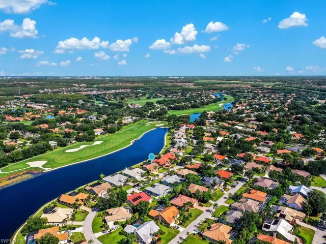 Aerial view of residential area with a golf course and a large body of water