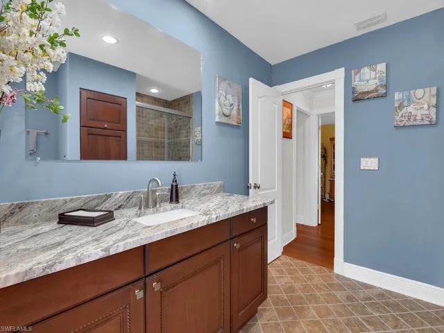 Bathroom featuring vanity, a shower stall, tile patterned flooring, recessed lighting, and crown molding