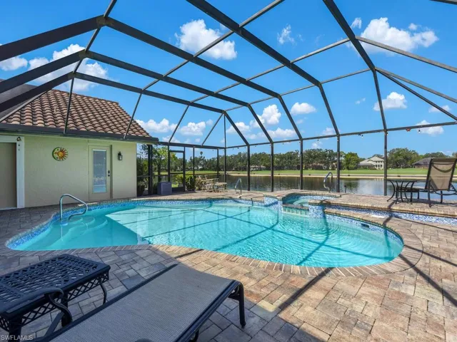 View of swimming pool with a water view, a pool with connected hot tub, a patio, and a lanai