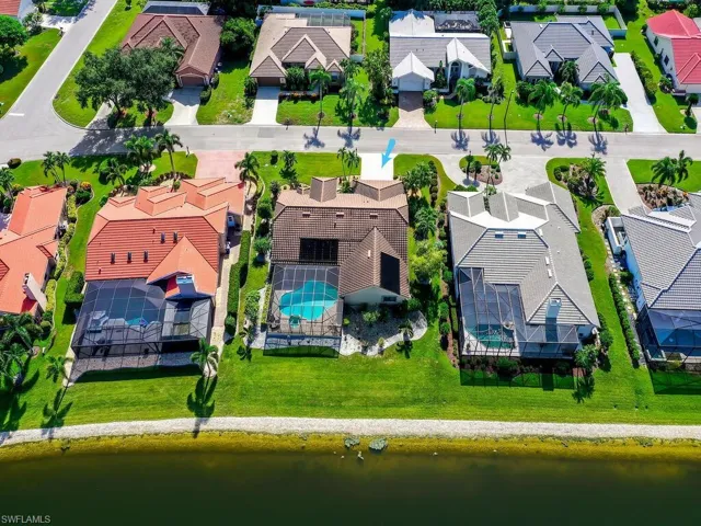 Aerial perspective of suburban area featuring a large body of water and a pool area