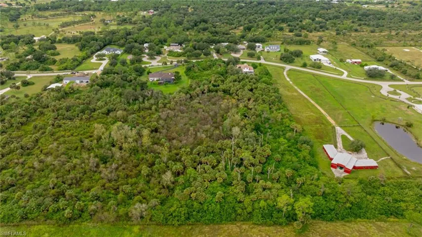 View of property location featuring a forest and a nearby body of water