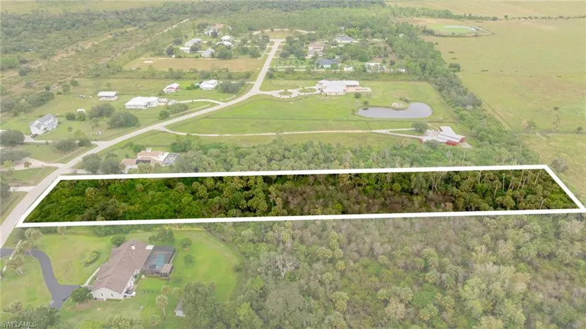 Aerial view of sparsely populated area with a heavily wooded area and property boundaries highlighted