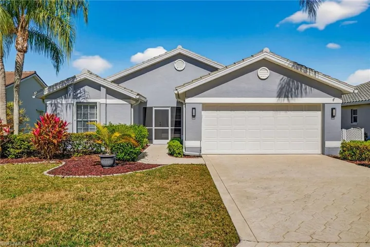 Ranch-style house featuring driveway, stucco siding, and a front lawn