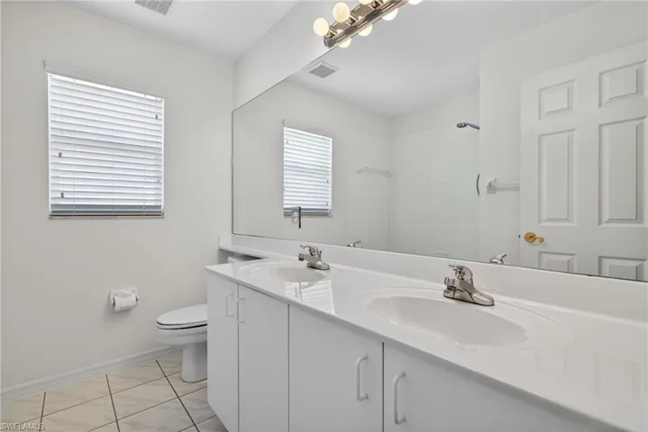 Bathroom with double vanity and a tile shower