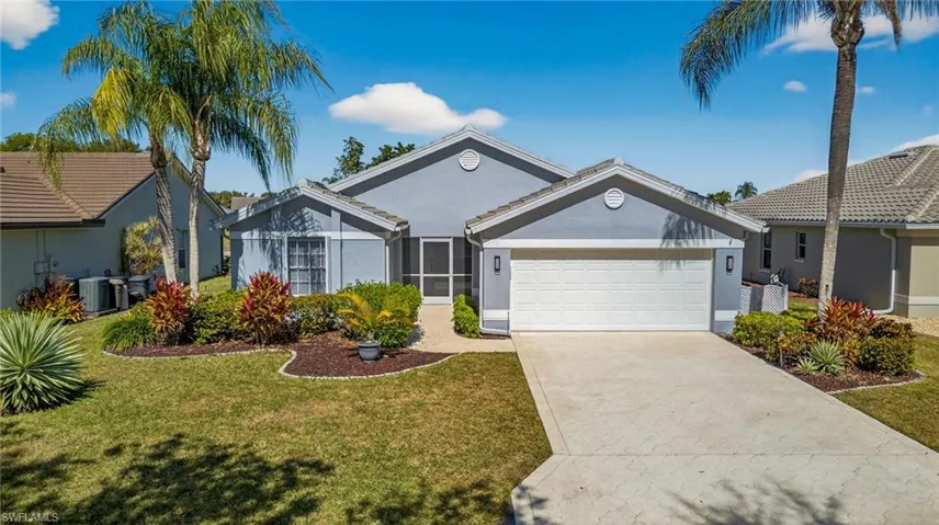 Ranch-style house featuring stucco siding, a front yard, driveway, and an attached garage