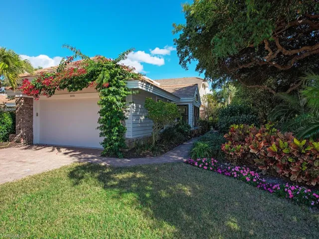 View of side of property with a yard, driveway, and an attached garage