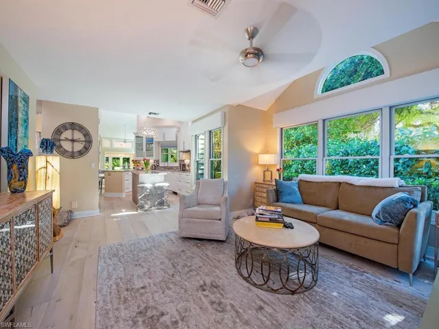 Den/office featuring light wood flooring, lofted ceiling, and plenty of natural light