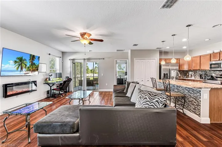 Living room with sink, dark hardwood / wood-style flooring, ceiling fan, and a textured ceiling