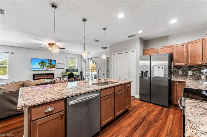 Kitchen featuring dark hardwood / wood-style flooring, sink, pendant lighting, and stainless steel appliances