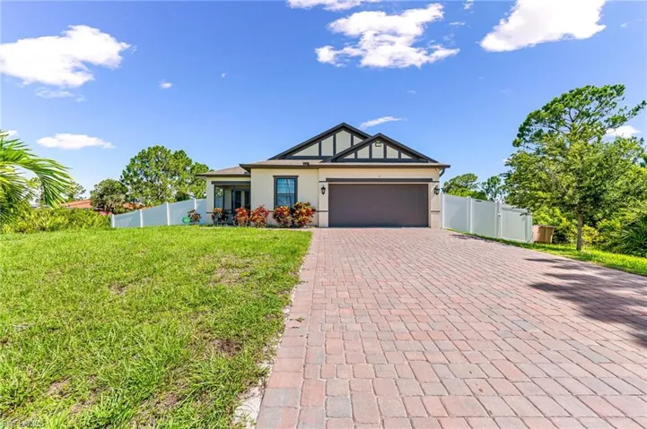 View of front of property featuring a garage and a front yard