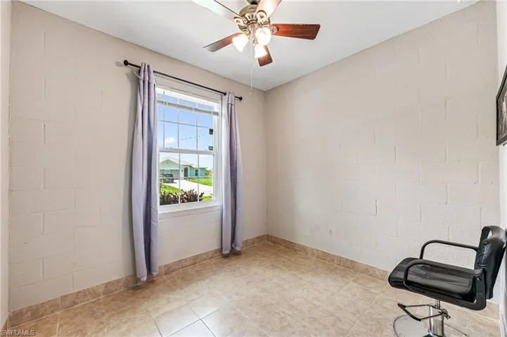 Unfurnished room featuring light tile flooring and ceiling fan