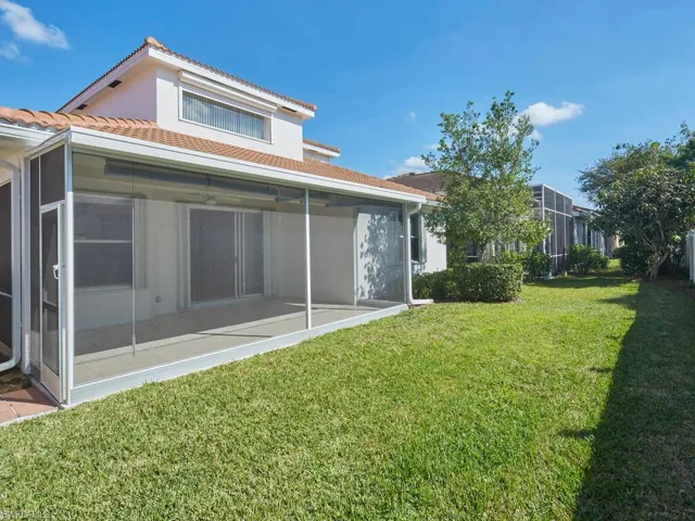 Rear view of property featuring a yard and a sunroom