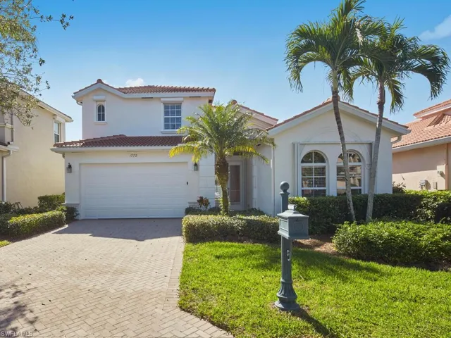 Mediterranean / spanish home featuring a garage and a front yard