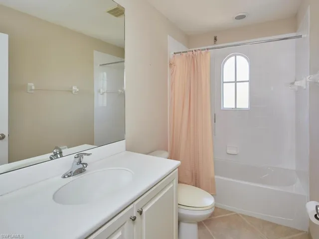 Full bathroom featuring vanity, shower / tub combo, tile patterned floors, and toilet
