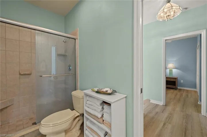 Bathroom with a shower stall and wood finished floors