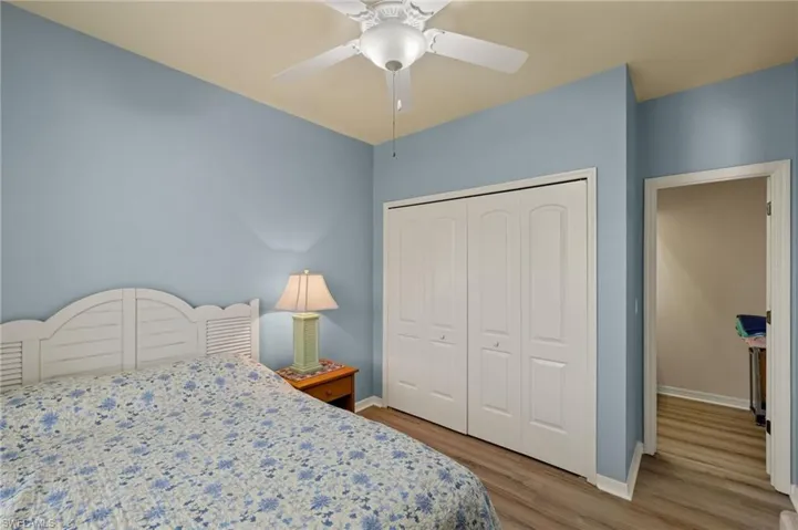 Bedroom with light wood-style flooring, a closet, and a ceiling fan