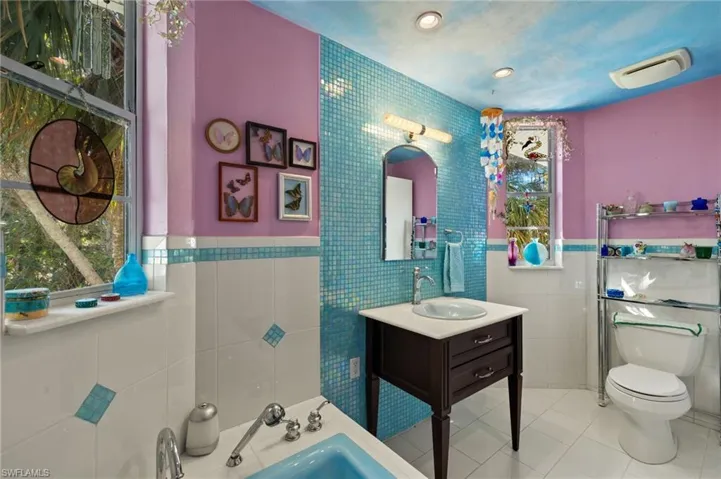 Full bath featuring tile walls, tile patterned flooring, vanity, and a garden tub