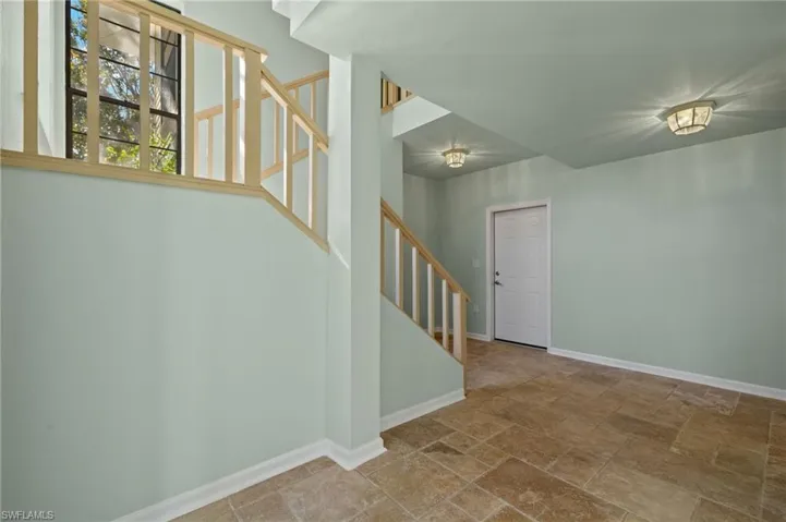 Below grade area featuring stairs and stone finish floors