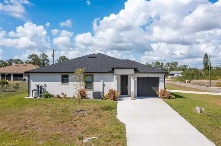 View of front of house featuring stucco siding, concrete driveway, an attached garage, and roof with shingles
