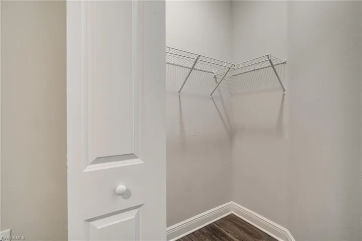 Walk in closet featuring dark wood finished floors