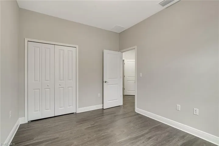 Unfurnished bedroom with dark wood finished floors and a closet